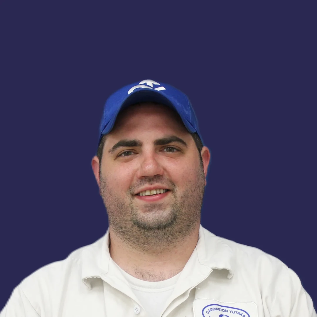Male employee smiling with company hat.